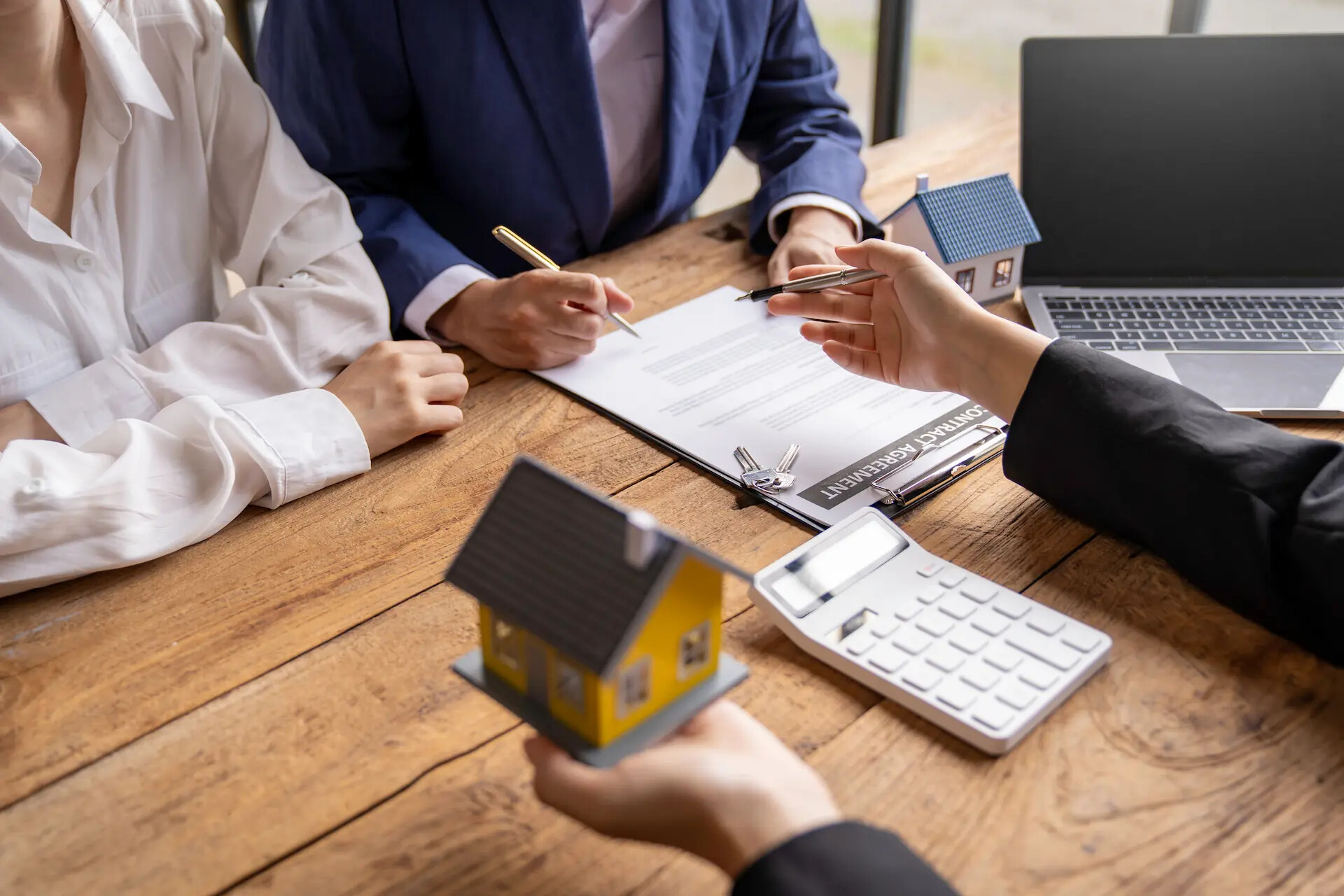 Real estate company to buy houses and land are delivering keys and houses to customers after agreeing to make a home purchase agreement and make a loan agreement. Discussion with a real estate agent.