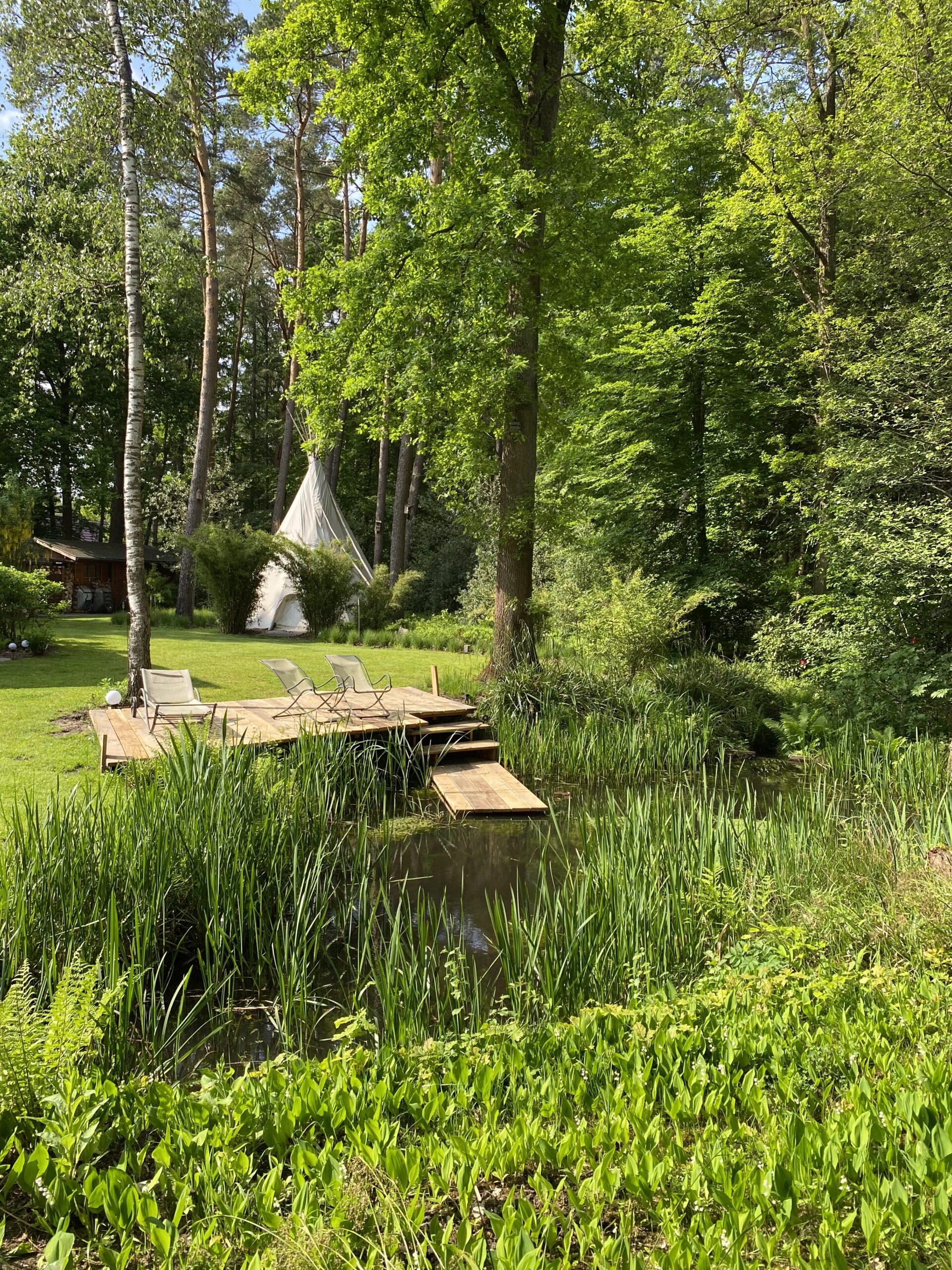 Gartenteich mit Tipi im Hintergrund