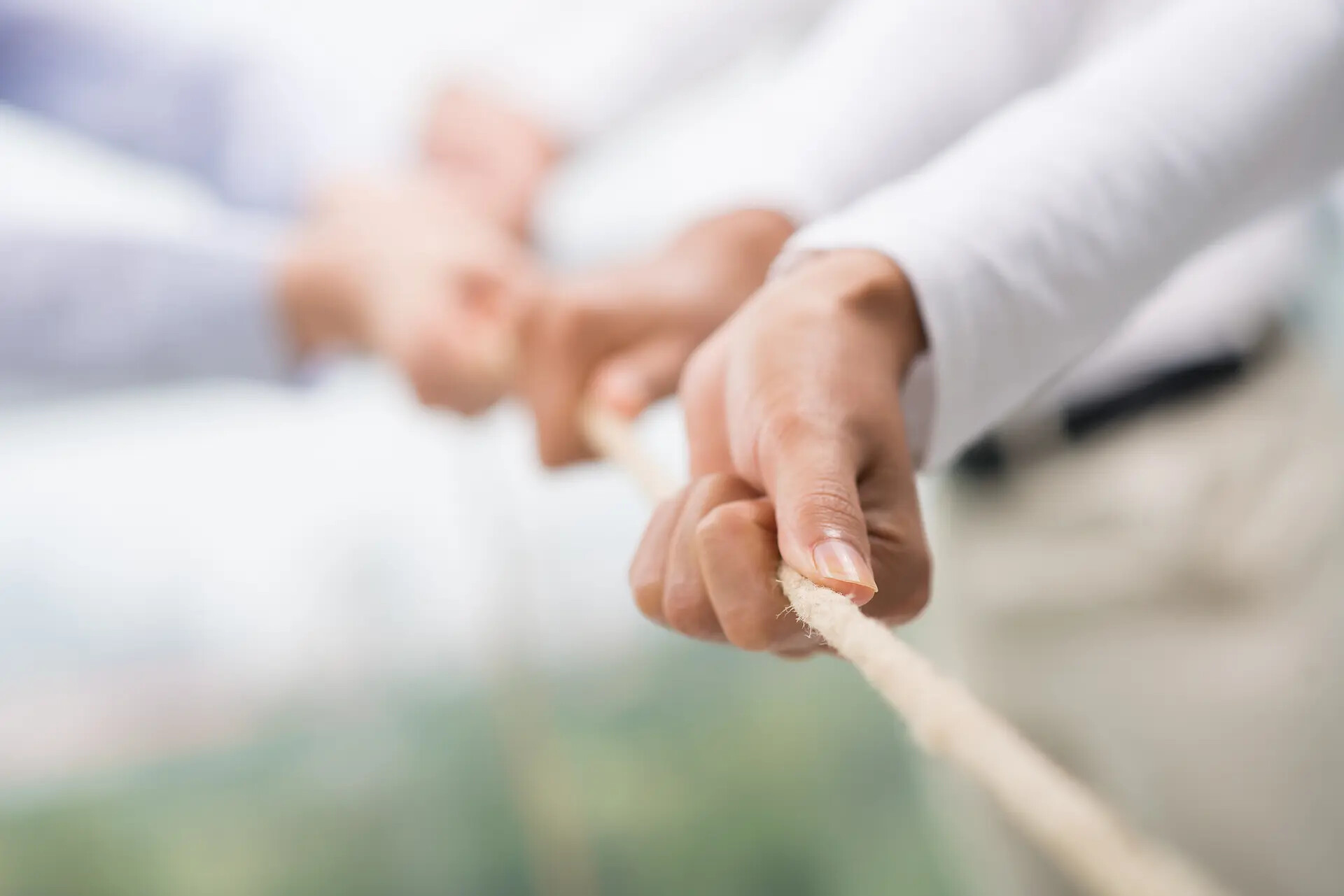 Mehrere Hände ziehen gemeinsam an einem Seil.