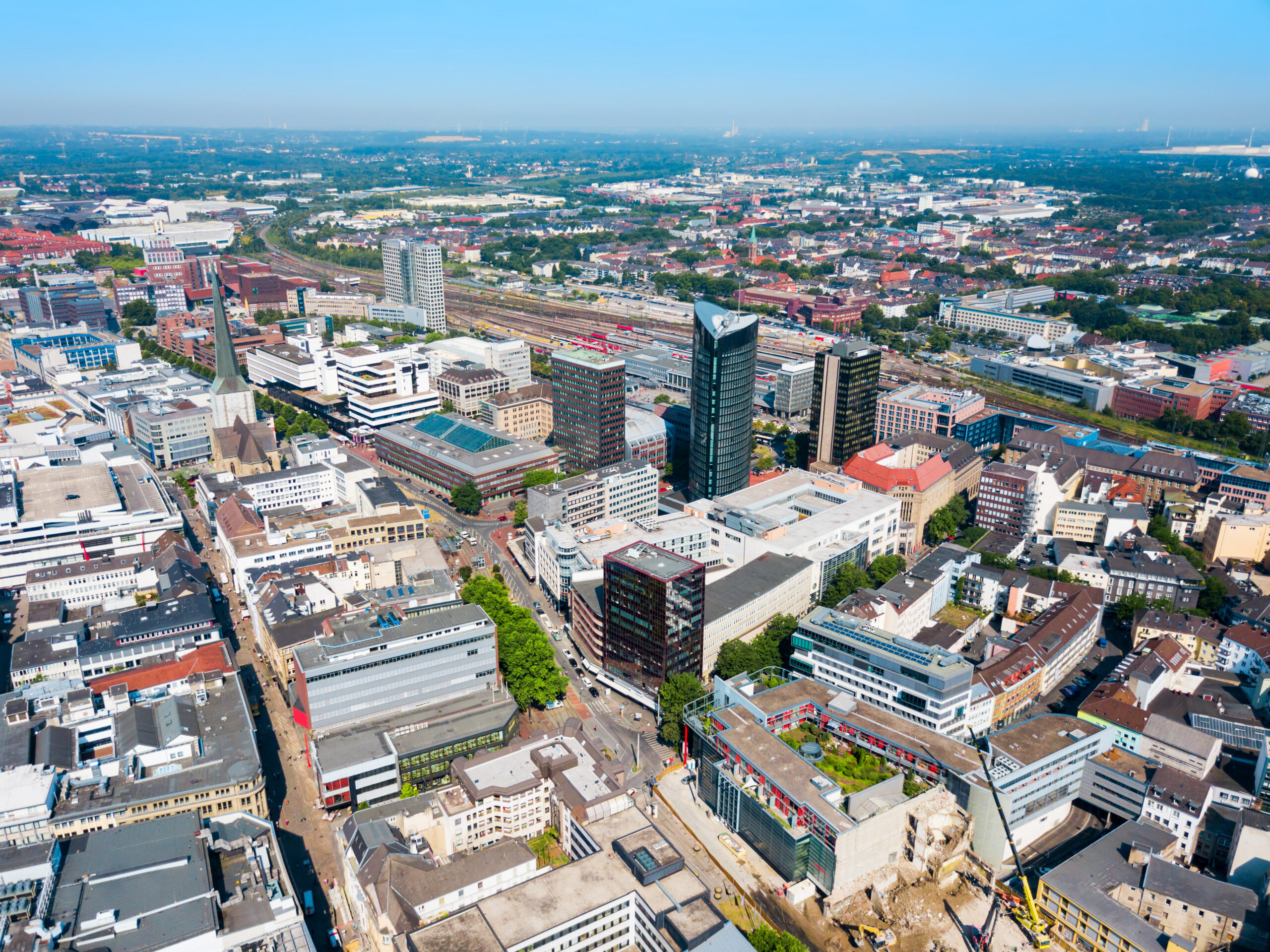 Moderne Gebäude, Straßen und Bahnhof an einem klaren Tag.