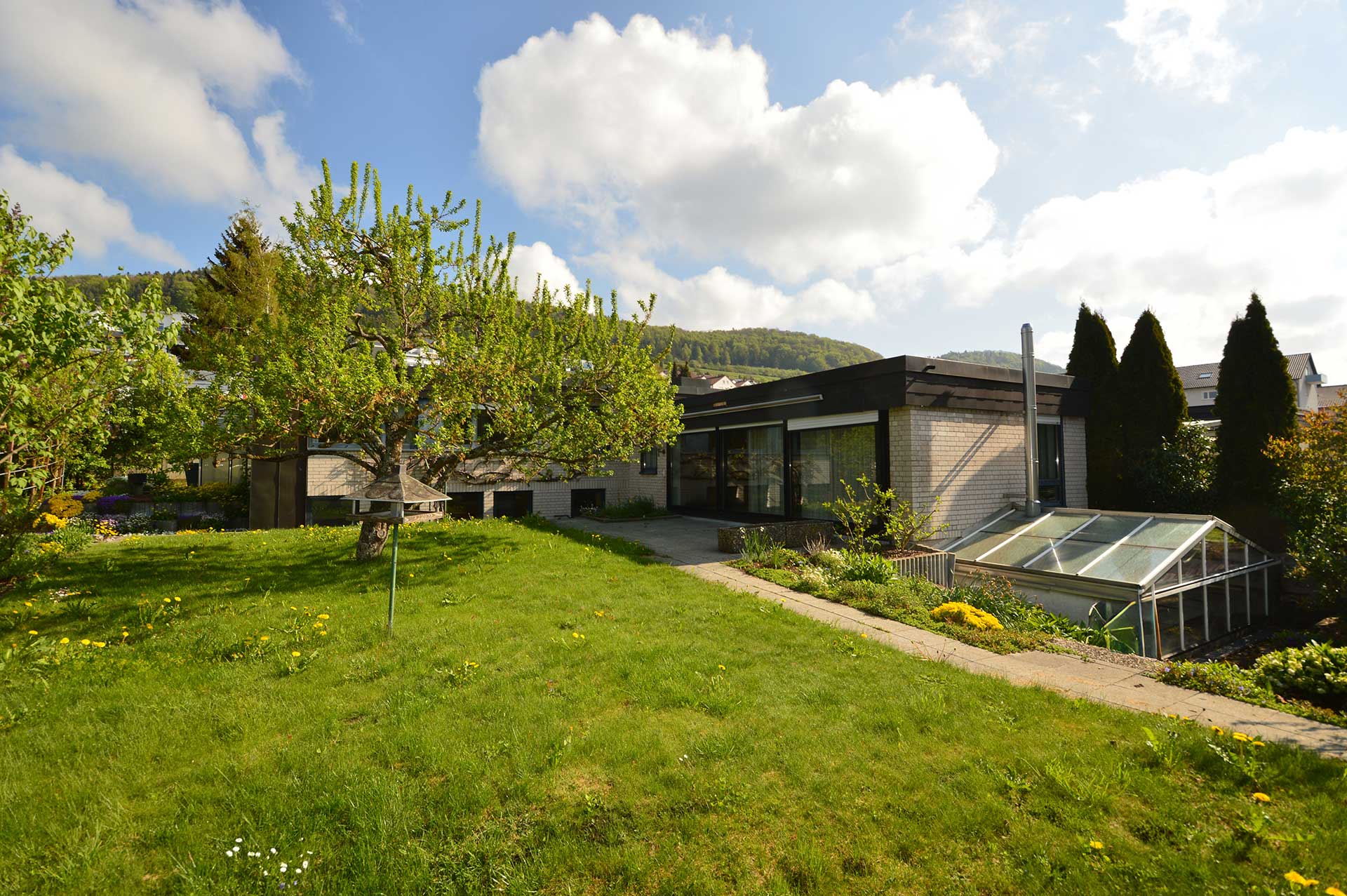Ansicht auf ein Einfamilienhaus im Hang mit Terrasse