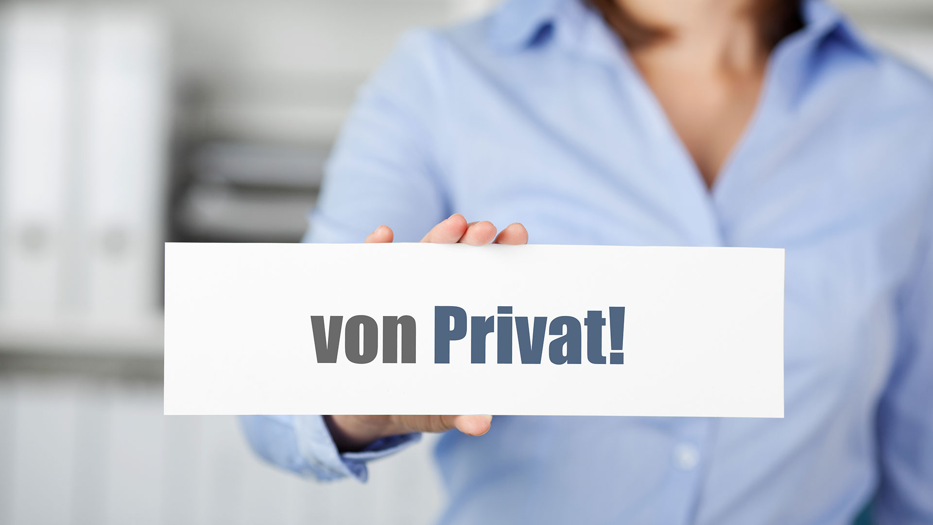 Eine Frau hält ein Schild mit der Aufschrift "von Privat!" in einer Hand vor sich