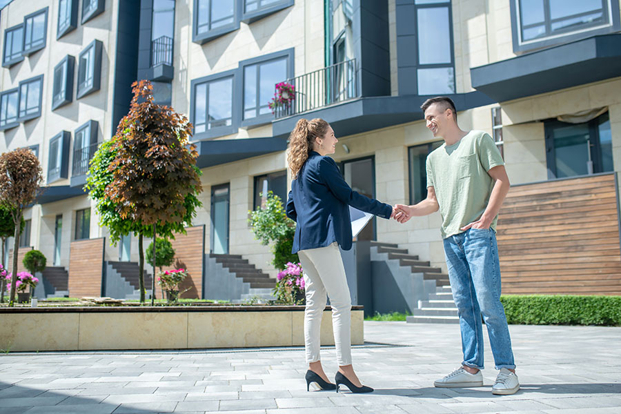Seriöse, gute Immobilienmaklerin schüttelt Ihrem Kunden die Hand