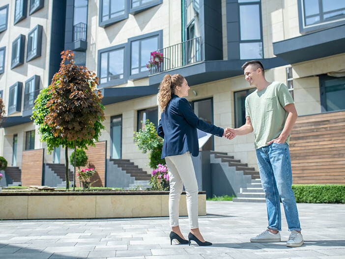 Seriöse, gute Immobilienmaklerin schüttelt Ihrem Kunden die Hand