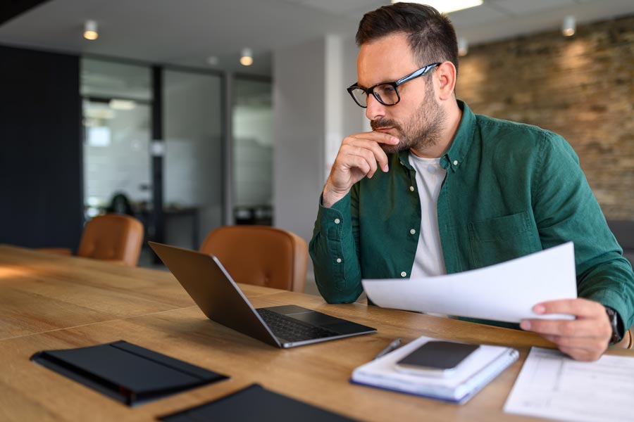 Mann schaut sich Gedankenvoll die Immobilienpreise am Laptop an
