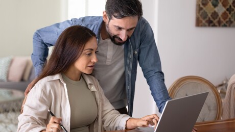 Mann und Frau schauen gemeinsam auf Laptop