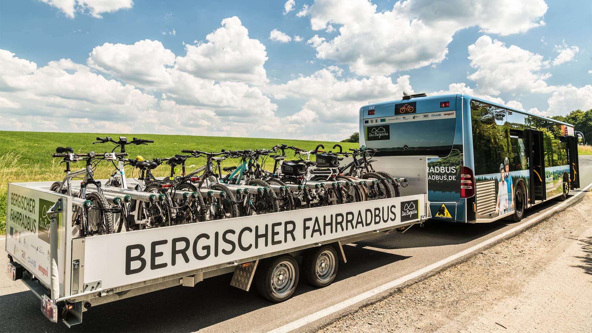 Bus mit Fahrradanhänger "Bergischer Fahrradbus" an der Landstraße.