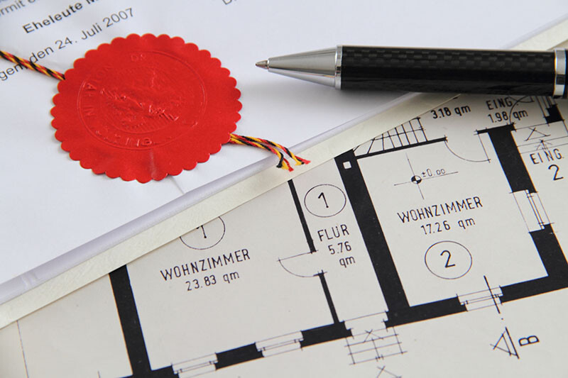 Stift, rotes Siegel und Grundriss mit deutschem Text.