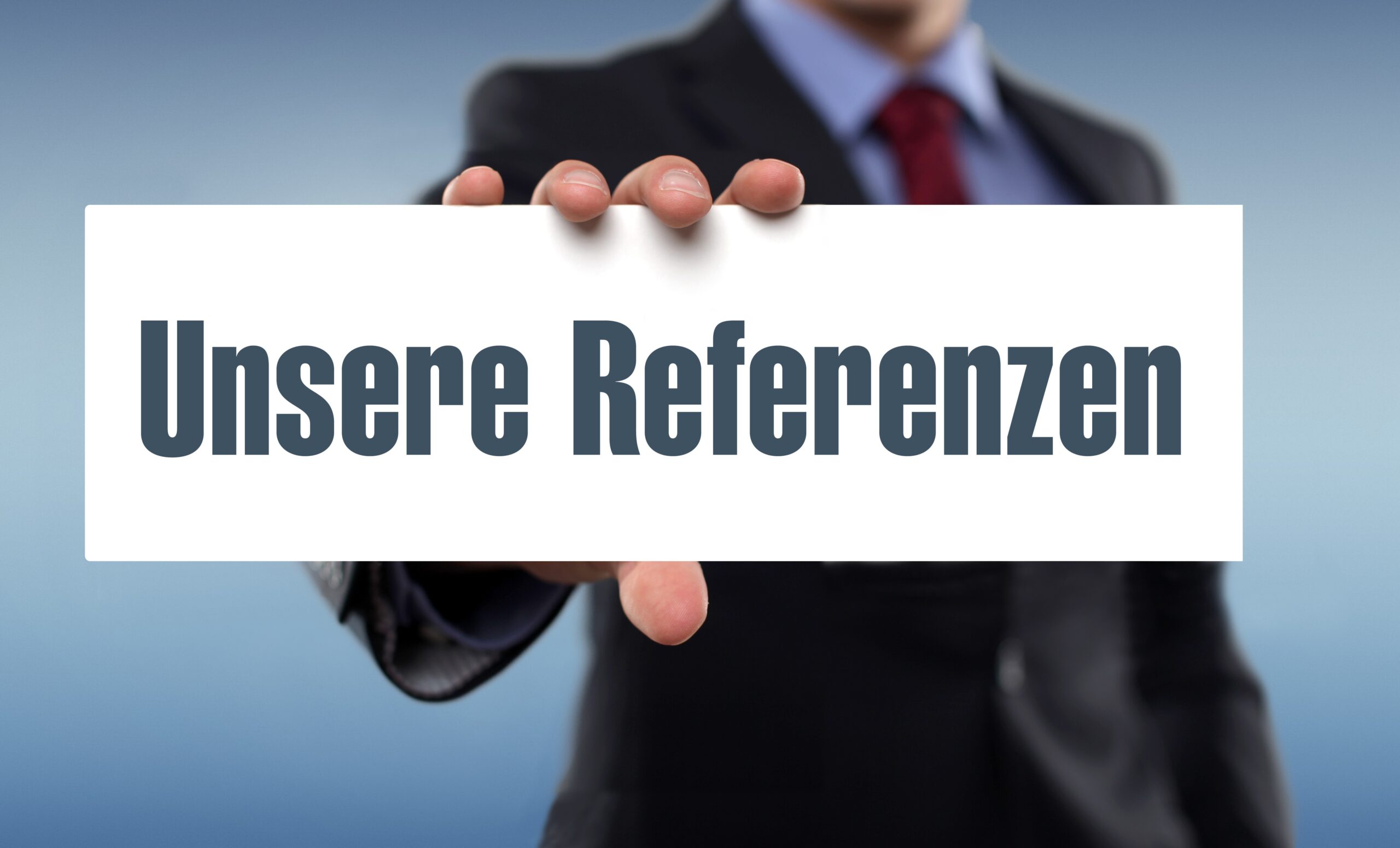 Mann hält Schild mit Aufschrift Unsere Referenzen