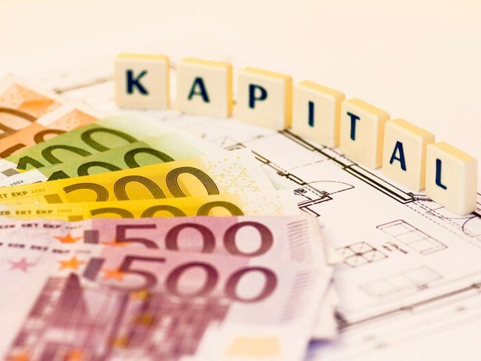 Würfel mit Aufschrift Kapital und Grundriss