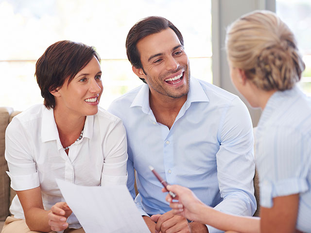 Immobilienmaklerin berät Paar zum Hauskauf