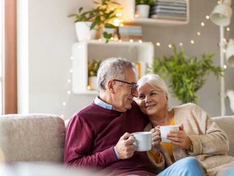 Glückliches altes Ehepaar Wohnzimmer, genießen das Wohnen in einem altersgerechten Zuhause
