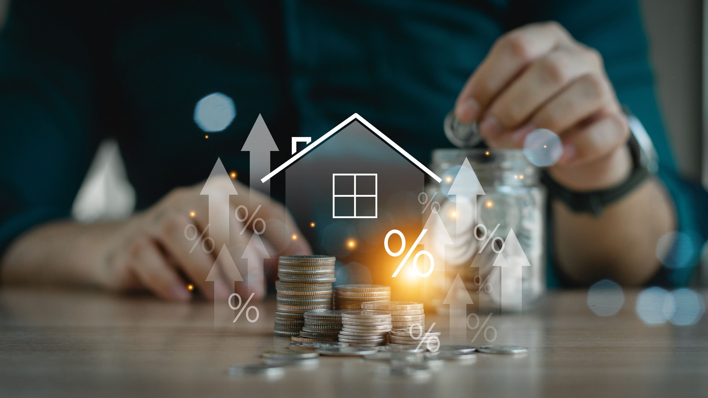 Mensch sitzt vor Münzstapel, darüber befindet sich ein digitales Haus mit Pfeilen nach oben, Wertsteigerung einer Immobilie in Gangelt