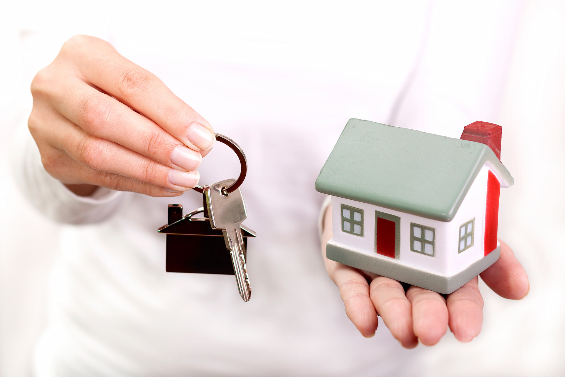 Modellhaus und Schlüssel in der Hand