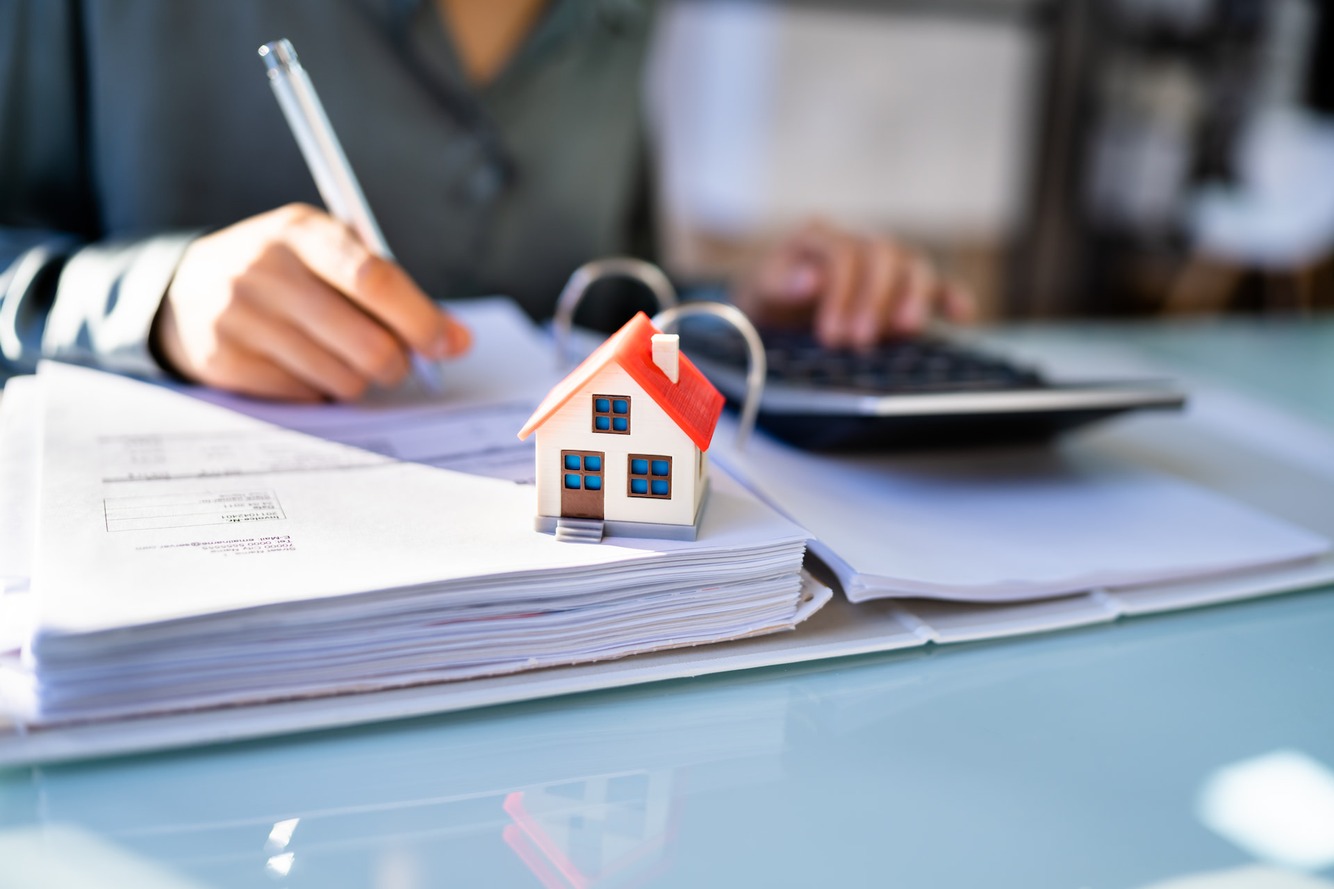 Taschenrechner neben Modellhaus