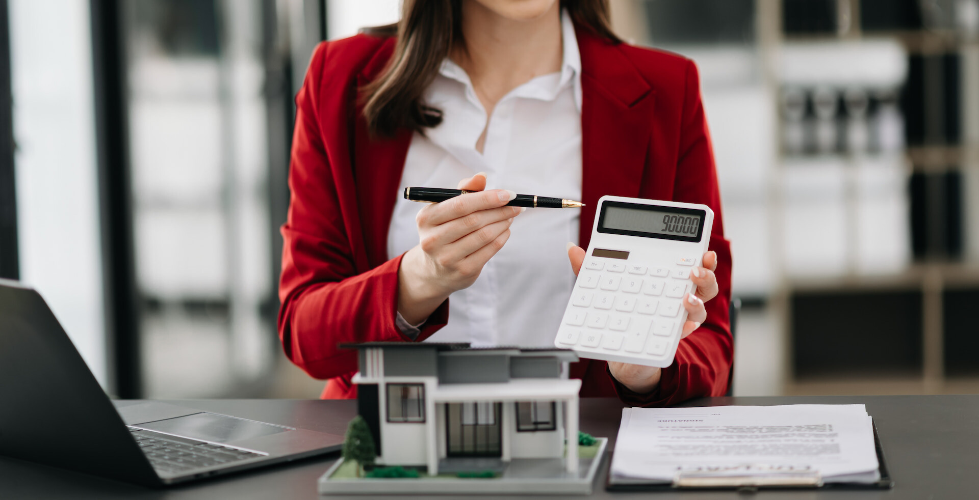 Makler hält Taschenrechner hoch