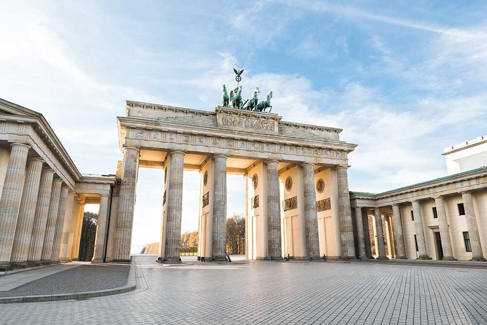 Brandenburger Tor in Berlin bei Sonnenschein und blauem Himmel.
