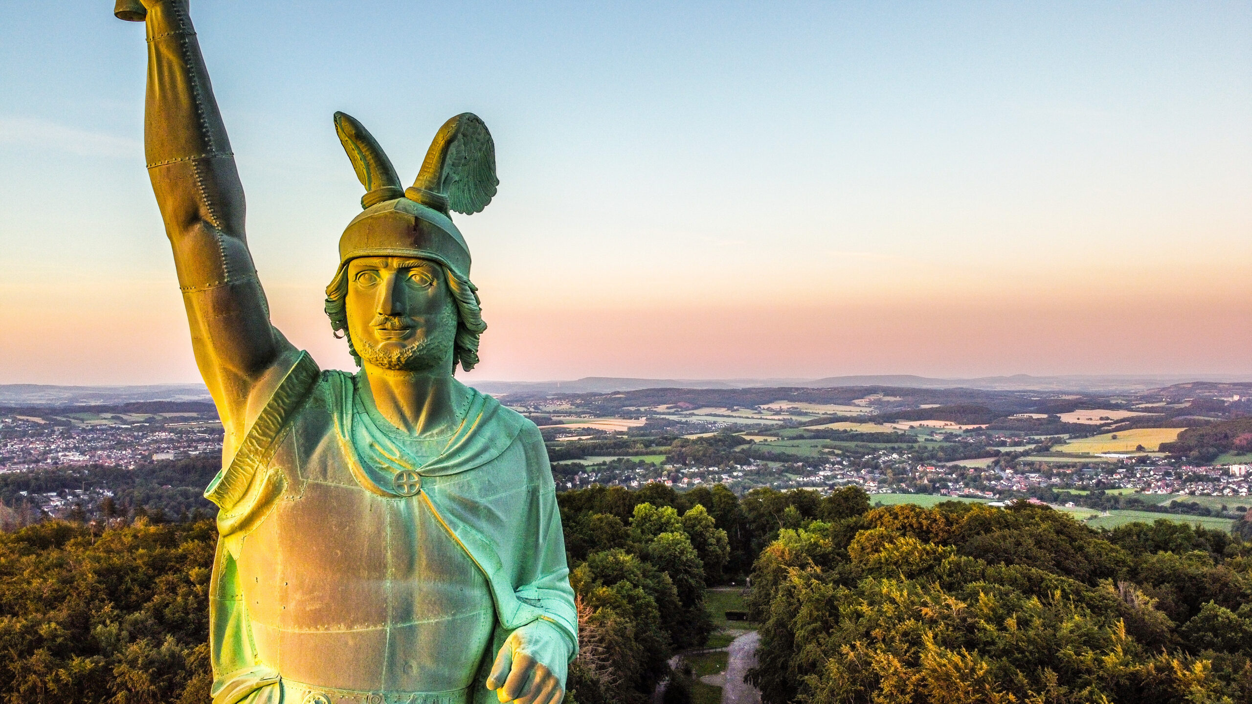 Hermann Statue blickt bei Sonnenuntergang auf den Wald.