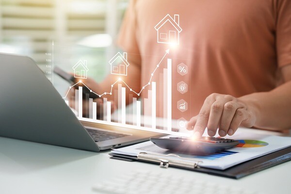 Person sitzt vor Laptop, davor ein digitaler Graph