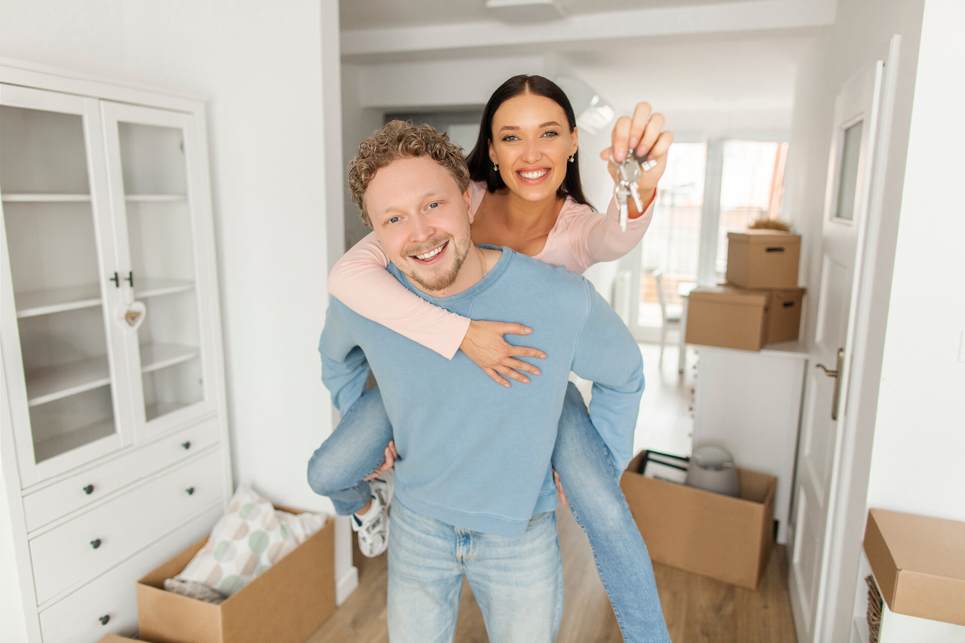 Pärchen beim Umzug hält Schlüssel in Händen