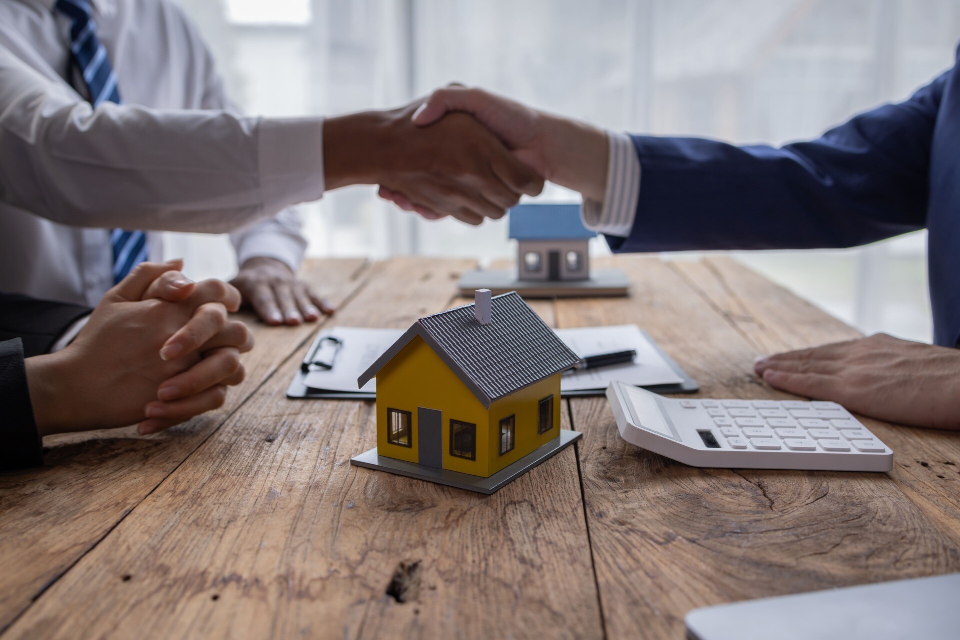 Handschlag über Modellhaus