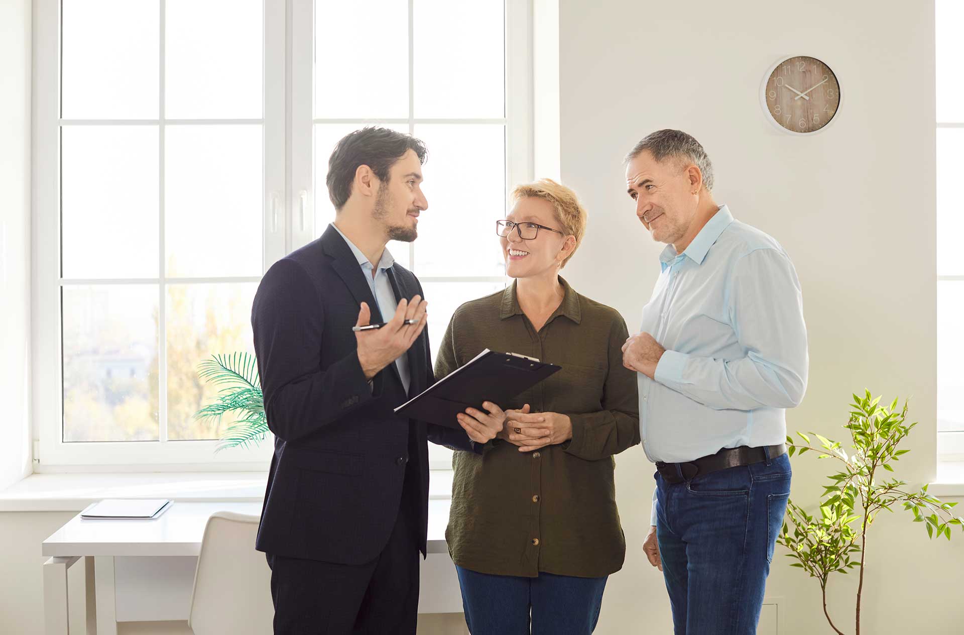 Seriöser Immobilienmakler berät zwei Interessenten