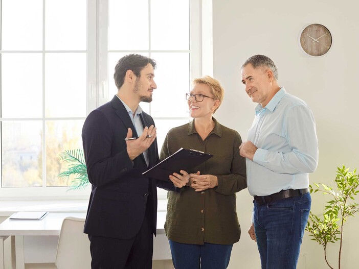 Seriöser Immobilienmakler berät zwei Interessenten