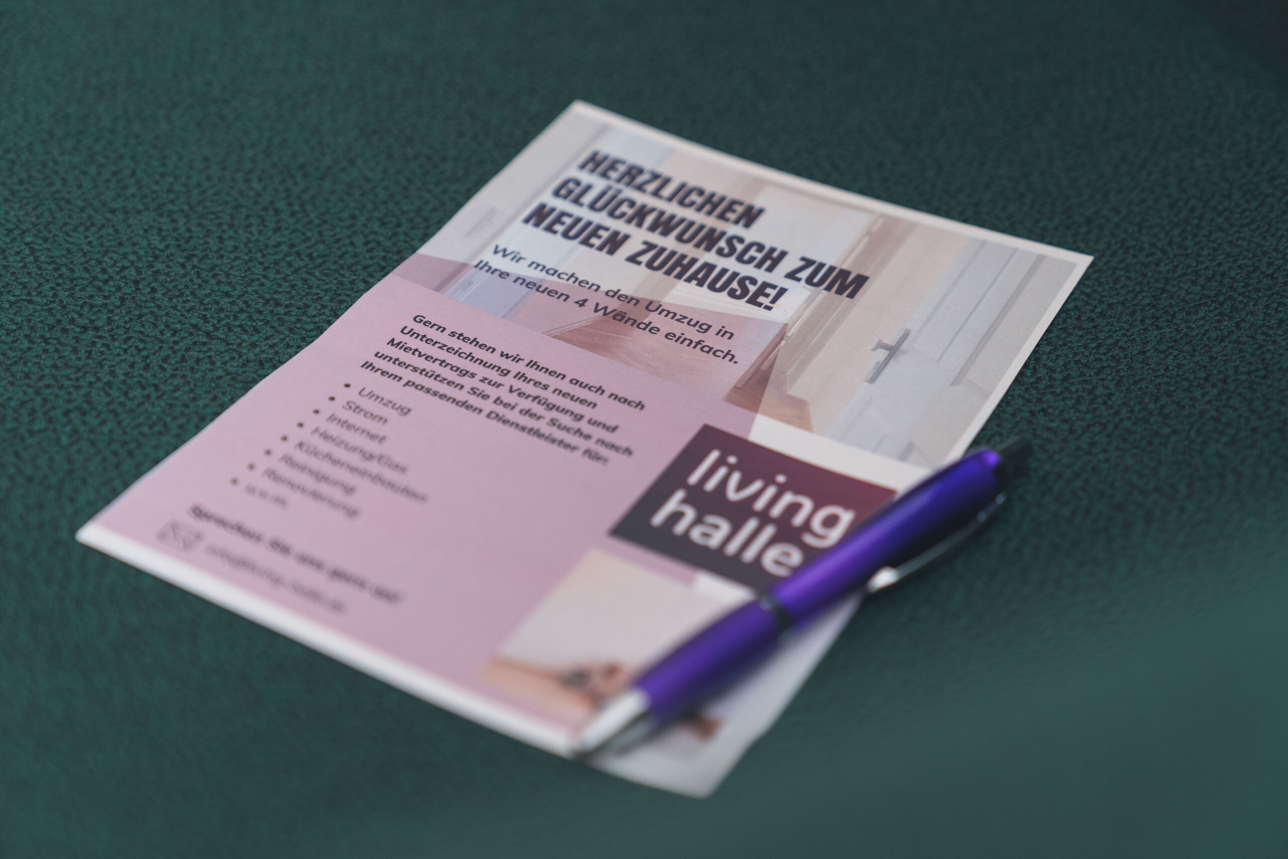 Lila Stift auf deutschem Flyer, Begrüßung, grüner Untergrund.