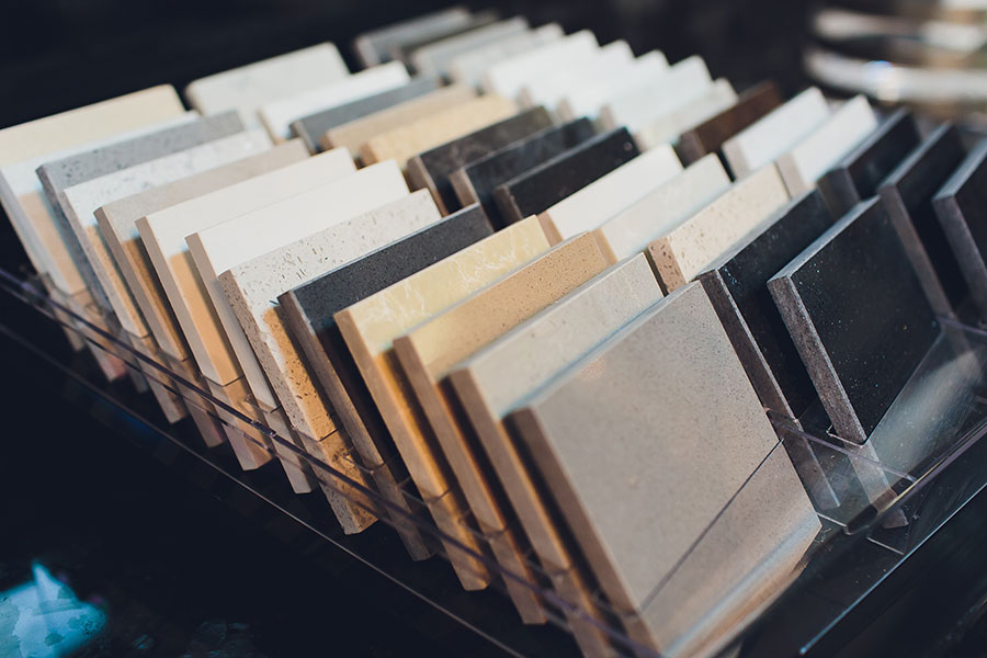 Muster von Arbeitsplatten aus Stein in verschiedenen Farben und Texturen in Reihen angeordnet.