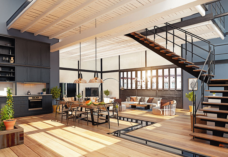 Offene Küche und Wohnbereich unter schwarzer Metalltreppe im Loft.