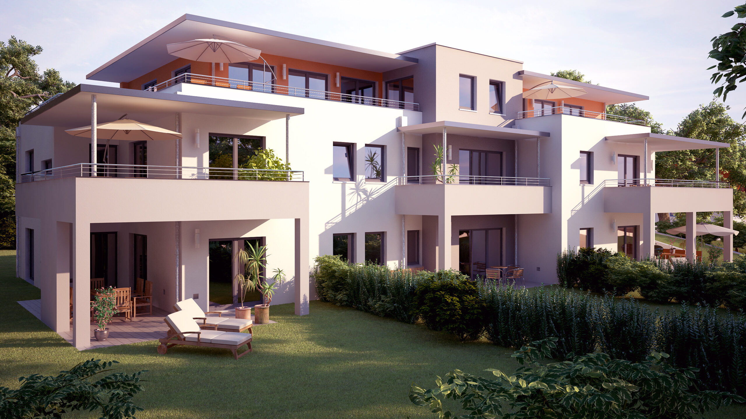 Weißes Wohnhaus mit Balkonen, großen Fenstern und Grünfläche.