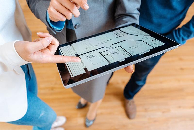 Person zeigt auf Grundriss am Tablet