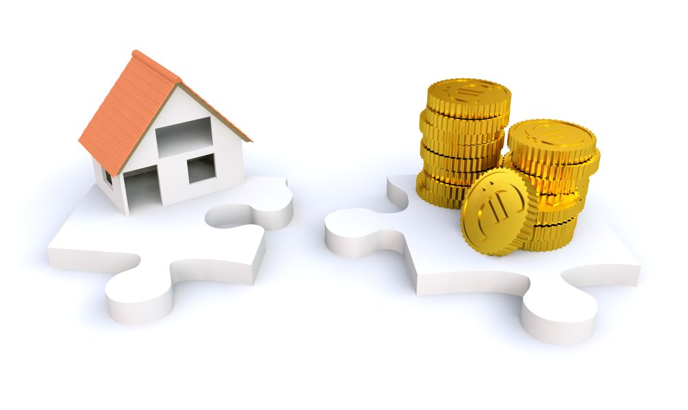 Miniatur Haus und Geld auf zwei Puzzlestücken