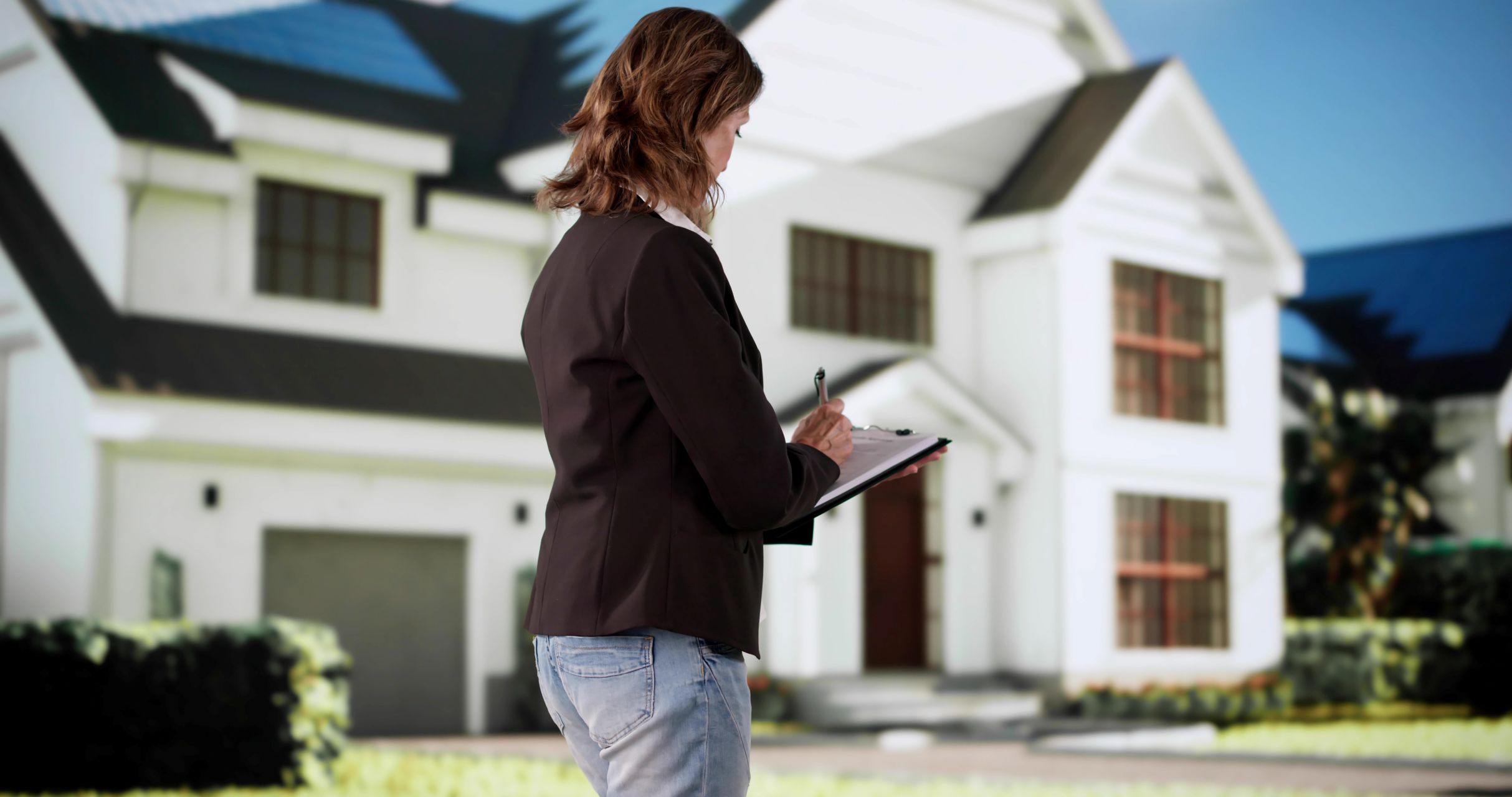 Frau mit Klemmbrett vor großem weißen Haus.