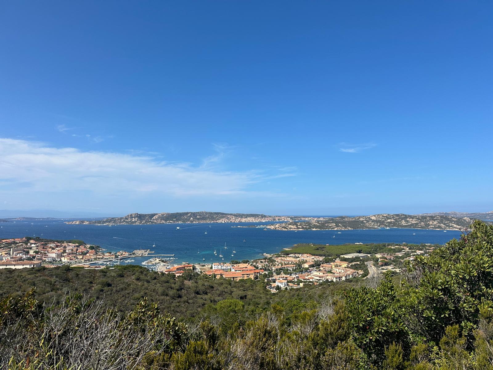 Küstenstadt con Gebäuden, Marina e Meer unter blauem Himmel.