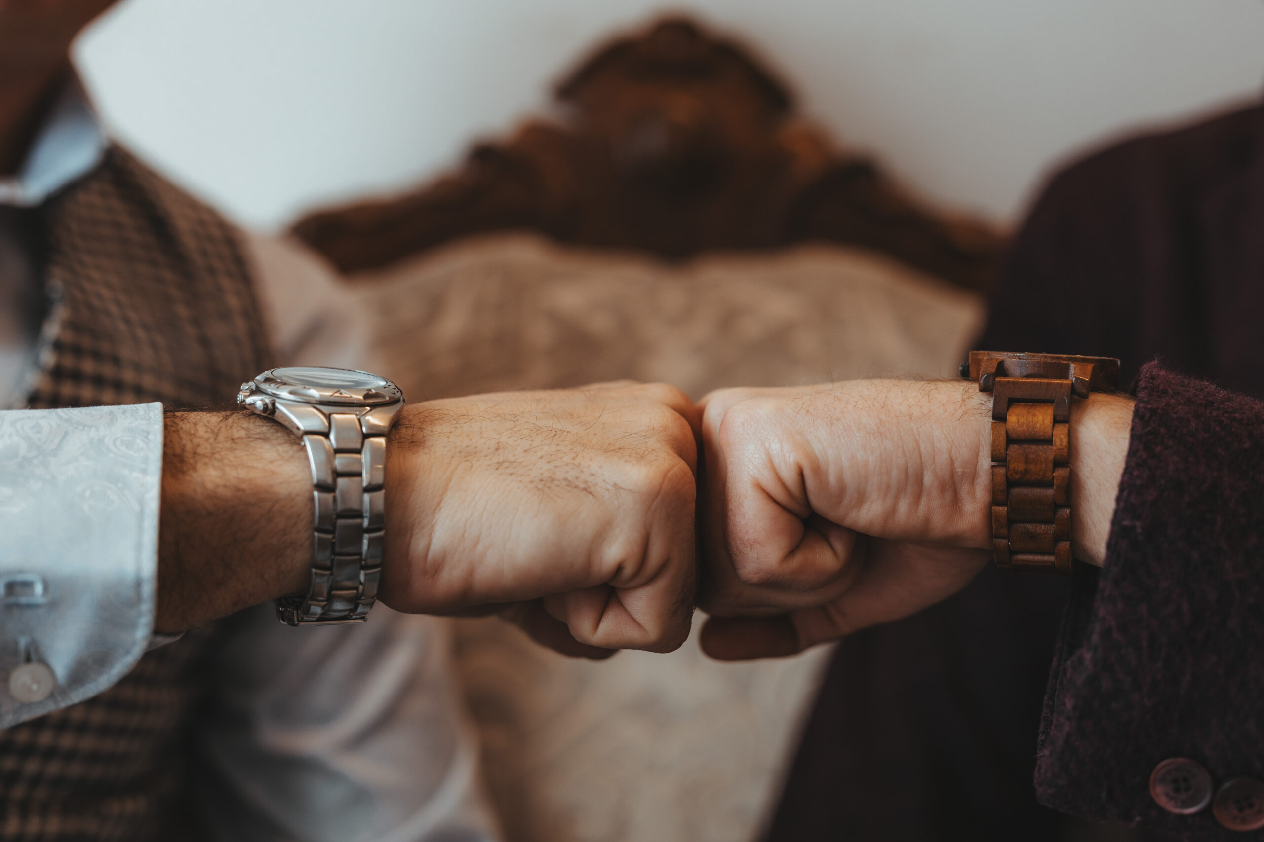 Pugno di ferro tra due persone, ognuna con un orologio diverso.