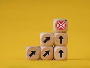 Mehrere gestapelte Holzwürfel mit Pfeilicons darauf