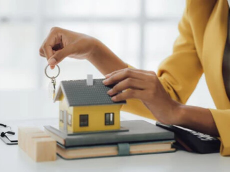 Schlüsselübergabe durch eine Immobilienmaklerin