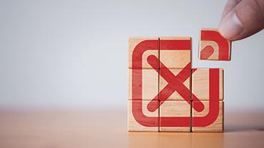 Mehrere gestapelte Holzwürfel bilden ein rotes X