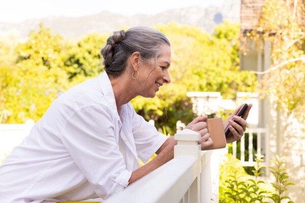 Eine Frau steht auf der Terrasse Ihres Ferienhauses