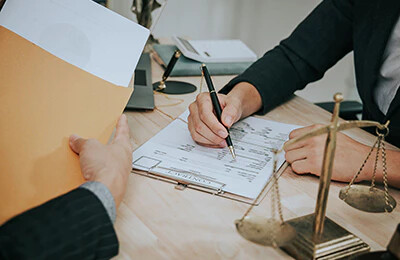 Eine Person unterzeichnet ein Dokument bei einem Immobilienmakler