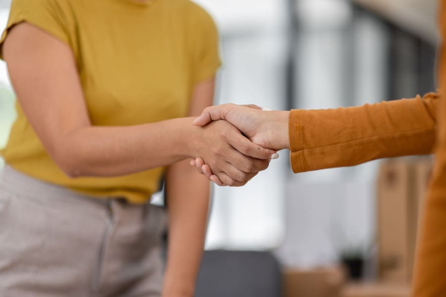 Ein Immobilienverkäufer und der Käufer geben sich die Hand