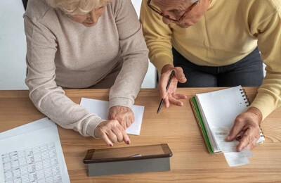 Ein älteres Ehepaar recherchiert am Schreibtisch