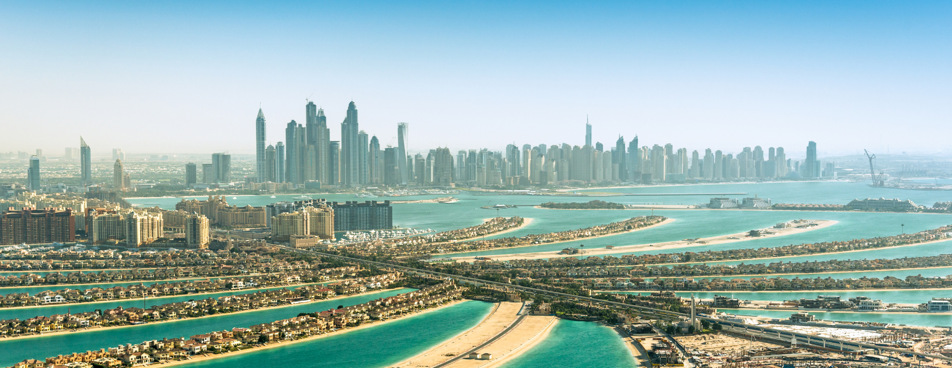 Palm Jumeirah und Dubais Skyline unter klarem Himmel.