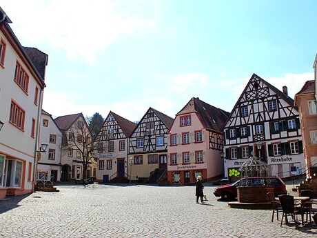 Stadtplatz mit Kopfsteinpflaster und bunten Fachwerkhäusern.