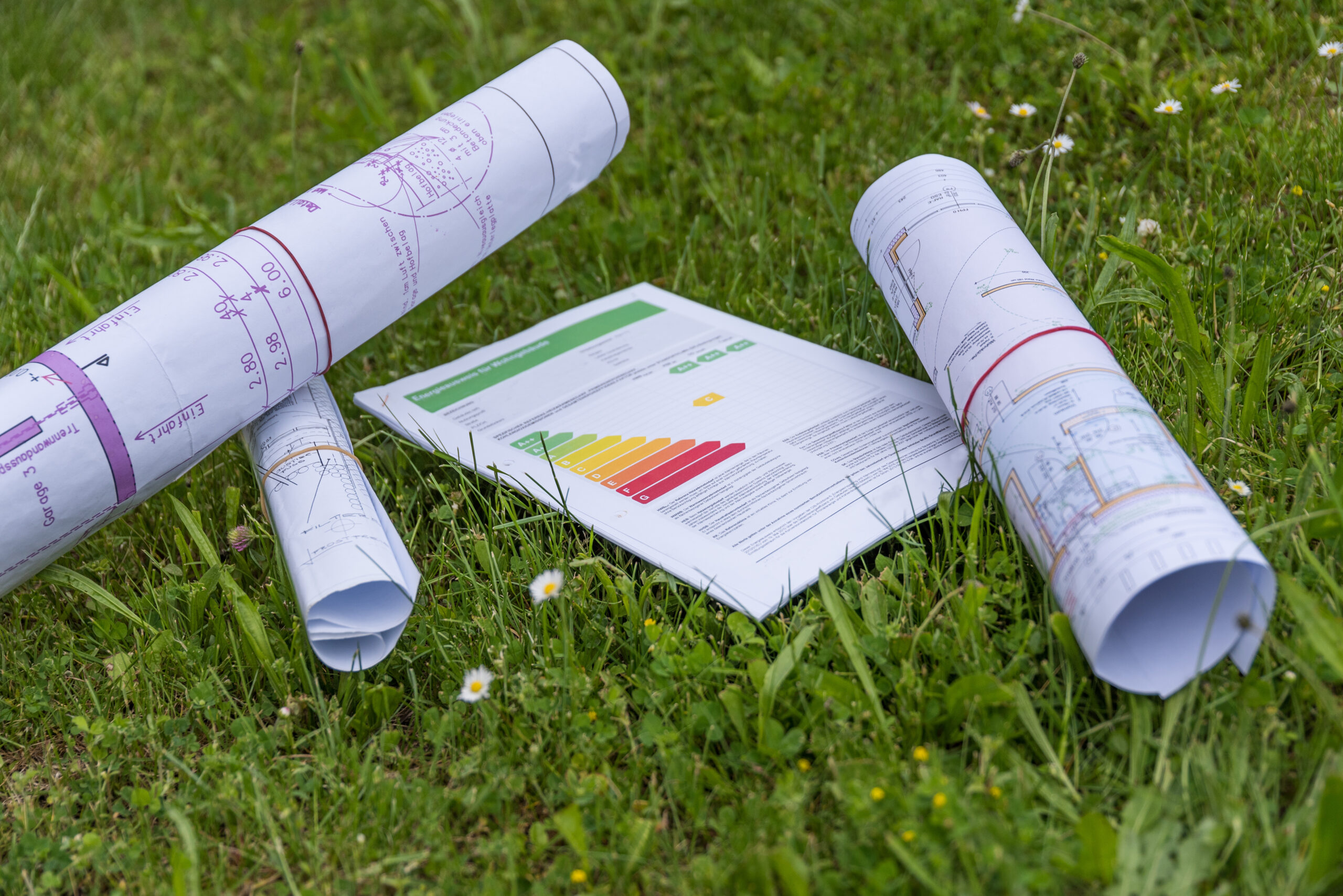 Grundrisse und Energieausweis liegen auf Wiese