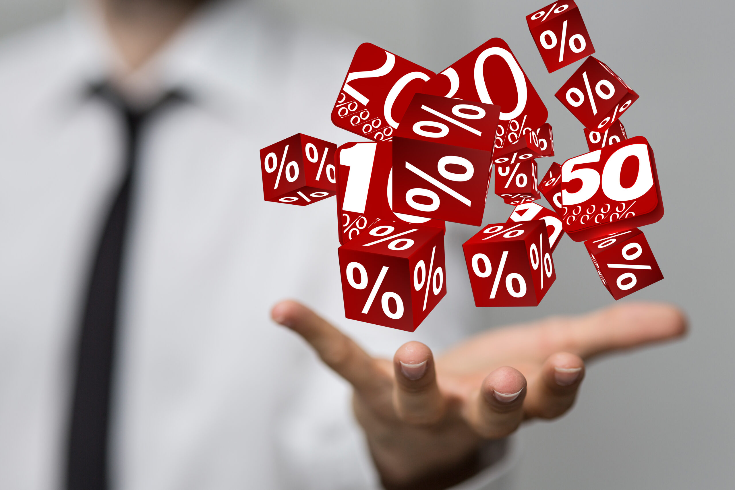 Würfel mit Prozentzeichen schweben über geöffneter Hand