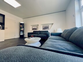 Eine moderne Sitzecke im Immobilienbüro von Meer.Ostsee Immobilien mit historischen Ansichten von Stralsund