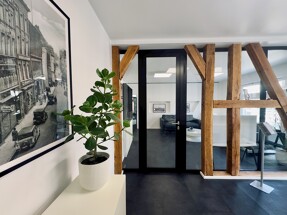 Die moderne Trennwand aus Glas im Büro von Meer.Ostsee Immobilien im Frankendamm in Stralsund sowie eine historische Ansicht von Stralsund als Bild