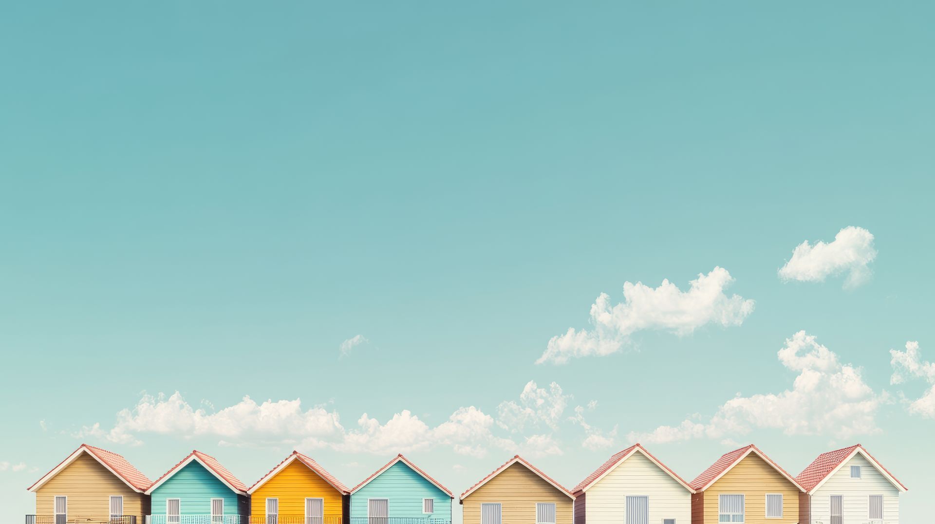 Bunte Häuser mit spitzen Dächern unter blauem Himmel.